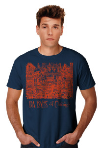 Young man wearing a navy blue t-shirt with a graphic design featuring a stylized outline of buildings and the text "pubsOf Downtown Chicago.