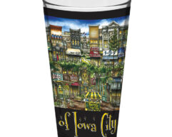A colorful souvenir cup featuring an artistic portrayal of Lawrence, KS landmarks and street scenes, with the text "of Lawrence, KS" at the bottom.
